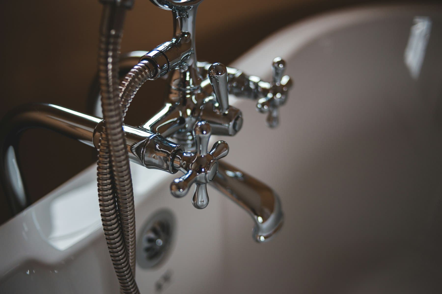 Exposed copper and PVC plumbing under a bathroom sink